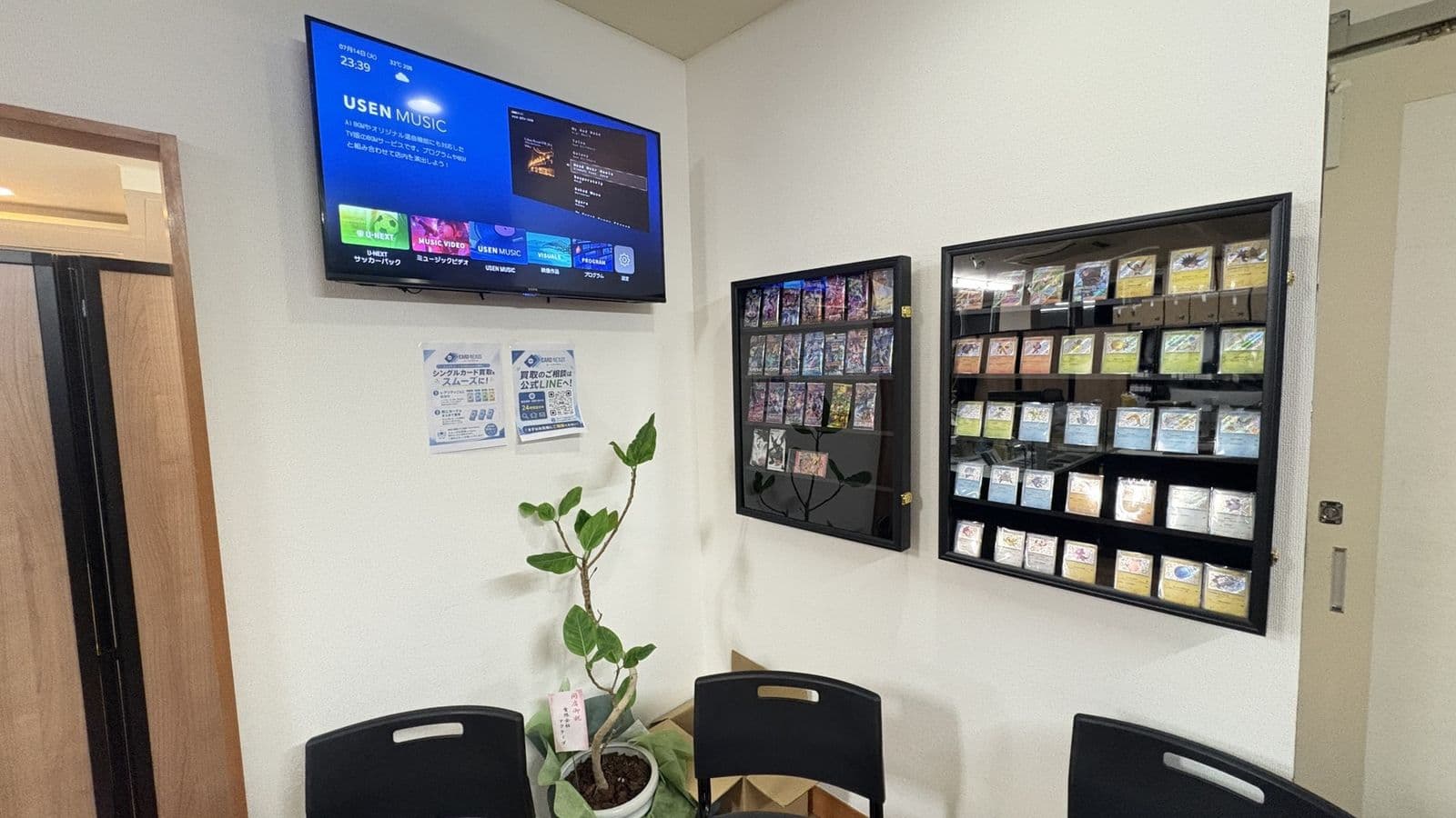 Samurai Card Hub office display corner with card showcases and a TV